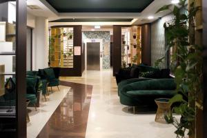 una hall con divani verdi in un negozio di Hotel Wellamarin a Zamárdi