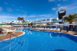a large swimming pool with chairs and umbrellas at THB Lanzarote Beach in Costa Teguise