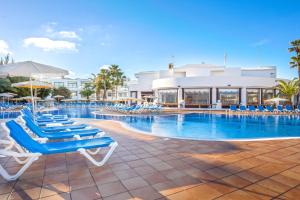 einen Pool mit Liegestühlen und ein Hotel in der Unterkunft THB Lanzarote Beach in Costa Teguise
