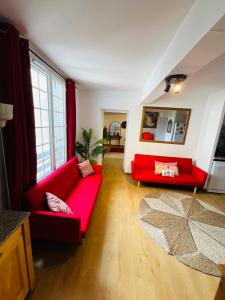 uma sala de estar com um sofá vermelho e uma janela em No 14 , 15 meters plein centre Mirepoix apartment Très Calme Netflix ,Terrace Sleeps 4 70 m2 em Mirepoix