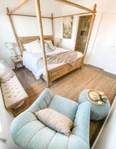 ein Schlafzimmer mit einem Bett und einem blauen Sofa in der Unterkunft OCEAN VIEW TOWNHOUSE Shell Cove in Dunmore