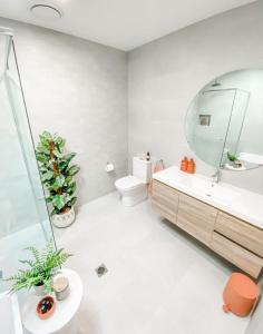 ein Badezimmer mit einem Waschbecken, einem WC und einem Spiegel in der Unterkunft OCEAN VIEW TOWNHOUSE Shell Cove in Dunmore