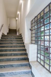 eine Treppe in einem Gebäude mit großen Fenstern in der Unterkunft Camere Cavour in Macerata