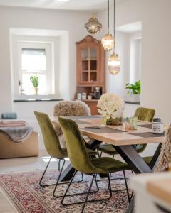 una sala da pranzo con tavolo e sedie verdi di AVA HOUSE a Podkoren