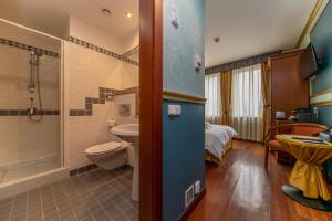 a bathroom with a sink and a toilet and a bed at Hotel Kinsky Fountain in Prague
