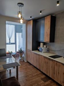 uma cozinha com uma bancada e um micro-ondas em Апартаменти в центрі Хмельницького (біля ТРЦ ЛибідьПлаза) em Khmelnytskyi