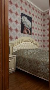 een slaapkamer met een bed en een foto aan de muur bij HanHome in Talghar