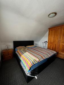 1 dormitorio con 1 cama y armario de madera en Apartments Morneweg, en Kronberg im Taunus