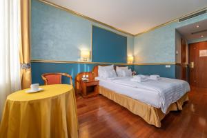 a hotel room with a bed and a table at Hotel Kinsky Fountain in Prague