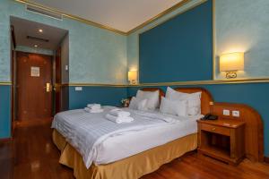 a bedroom with a large bed with towels on it at Hotel Kinsky Fountain in Prague