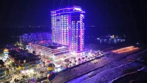 a tall building with purple lights on it at night at Flamingo Ibiza Hải Tiến in Nam Khê