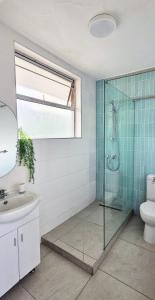 a bathroom with a shower and a toilet and a sink at La Ballito 305 in Ballito