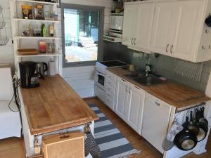 uma cozinha com armários brancos e um lavatório em Island Beach House em Värmdö
