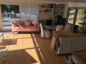 a living room with a couch and a kitchen with a table at Island Beach House in Värmdö