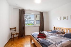 1 dormitorio con cama, ventana y silla en Bikerhäusle, en Gerstetten