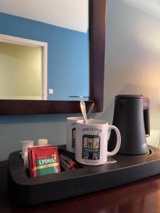 米爾敦馬爾貝的住宿－The Townhouse，盘子上放着两个咖啡杯和书