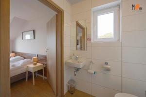 un bagno con un letto, un lavandino e uno specchio di Dom Wakacyjny MS Pro w Dźwirzynie a Dźwirzyno Altre 62 foto