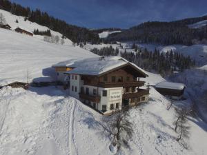 a snow covered house on a snowy mountain at Large Apartment in Maria Alm with Terrace in Maria Alm am Steinernen Meer
