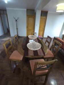 a wooden table and chairs in a room at Apart Happy Cata in Puno