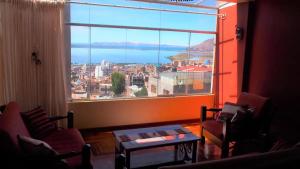 a room with a large window with a view of a city at Apart Happy Cata in Puno