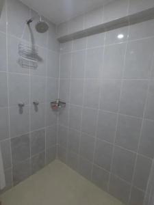a white tiled shower with a shower head at Apart Happy Cata in Puno
