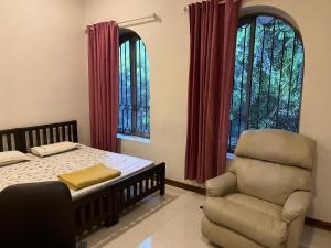 a bedroom with a bed and a chair at AAC in Chennai