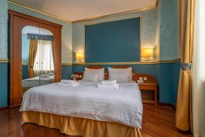 1 dormitorio con 1 cama blanca grande y pared azul en Hotel Kinsky Fountain, en Praga