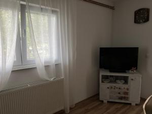 sala de estar con TV y ventana en EMINA, en Mostar