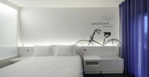 a bedroom with a white bed with a bike on the wall at Hotel 3K Europa in Lisbon