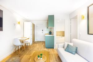 a living room with a couch and a table at Lavie Maison Balneo garden flat in Bordeaux