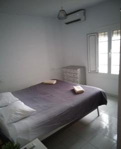 een bed in een witte kamer met een raam bij Villa Calle Montecillo in Alhaurín el Grande