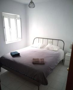 een slaapkamer met een bed met een deken en een raam bij Villa Calle Montecillo in Alhaurín el Grande