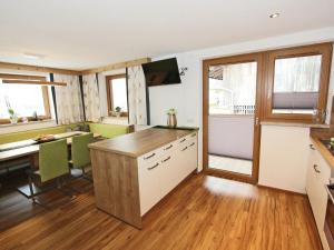 カルテンバッハにあるSpacious Holiday Home near Ski Area in Kaltenbachのデスクとテーブル付きのオープンキッチンが備わります。