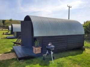 a bbq and a grill next to a shed at Piglet 2 in Yarmouth
