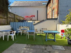 un groupe de tables et de chaises sur une pelouse dans l'établissement The Pilot Boat Inn, Isle of Wight, à Bembridge