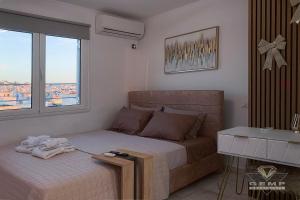 a bedroom with a bed and a desk and a window at Stunning Panoramic Athens view, 2 minutes metro in Athens
