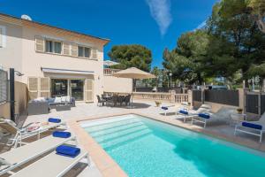 a swimming pool with lounge chairs and a house at Villa Isabella - Ideal Property Mallorca in Muro