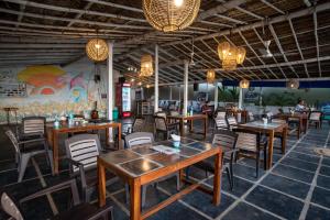 a restaurant with wooden tables and chairs and a mural at Sunset Cafe Beach Stay in Gokarna +114 photos