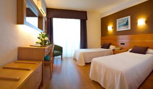 ハベアにあるHotel Villa Naranjosのベッド2台と窓が備わるホテルルームです。