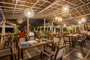 a restaurant with tables and chairs and lights at Sunset Cafe Beach Stay in Gokarna