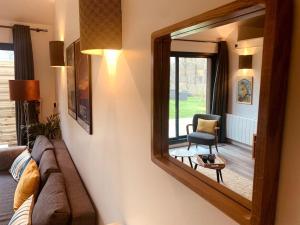 einen Spiegel im Wohnzimmer mit Sofa und Stuhl in der Unterkunft Jolie maison pleine nature, 1-4 p, parking gratuit in La Chapelle-sur-Erdre