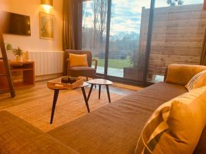 ein Schlafzimmer mit einem Bett, einem Stuhl und einem Tisch in der Unterkunft Jolie maison pleine nature, 1-4 p, parking gratuit in La Chapelle-sur-Erdre