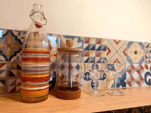 eine Flasche und zwei Weingläser auf einem Tisch in der Unterkunft Jolie maison pleine nature, 1-4 p, parking gratuit in La Chapelle-sur-Erdre + 15 Fotos