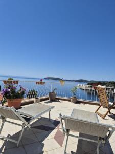 a patio with chairs and tables and the ocean at Apartmani Matea in Zaton