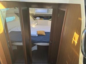 una piccola camera con un piccolo letto in una barca di Bella storia II a Mentone