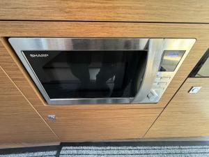 un forno a microonde in un cassetto in legno in un armadio di Bella storia II a Mentone