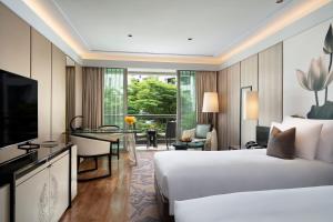 um quarto de hotel com uma cama e uma secretária em Siam Kempinski Hotel Bangkok - SHA Extra Plus Certified em Bangkok