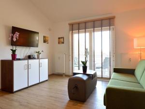 ein Wohnzimmer mit einem Sofa und einem TV in der Unterkunft Holiday resort Grafenmatt Feldberg in Feldberg