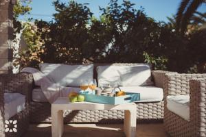 a wicker couch with a tray of fruit on a table at Villa Ananas by Abahana Villas in Moraira