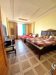 Malam Jabba的住宿－Sunshine Hotel & Restaurant，一间大卧室,配有两张床和椅子